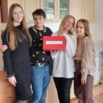 Cztery uczennice trzymają czerwone pudełko z napisem Walentynki