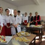Uczniowie z opiekunami w pracowni gastronomii prezentują wypieki