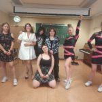 7 uczennic pozuje do zdjęcia ( dwie z nich w strojach tanecznych)