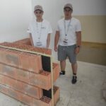 Dwóch uczniów prezentują efekty swojej pracy na olimpiadzie budowlanej