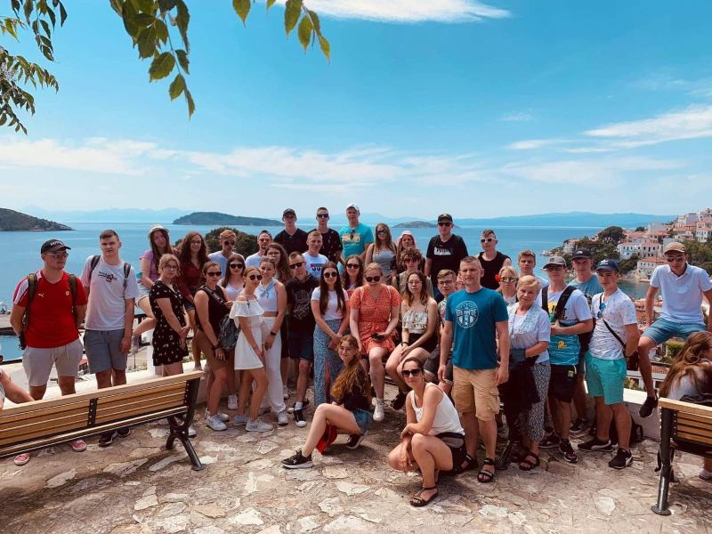Grupa uczniów z wychowawcami na tle pięknego widoku w Grecji