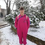 Na zdjęciu chłopak w piżamie w zimowej scenerii na boisku szkolnym