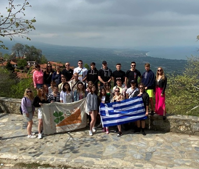 Grecja - grupa uczniów z flagą Grecji i Logo naszej szkoły